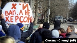 Люди стоят перед военными России во время митинга против российской оккупации. Херсон, 14 марта 2022 года